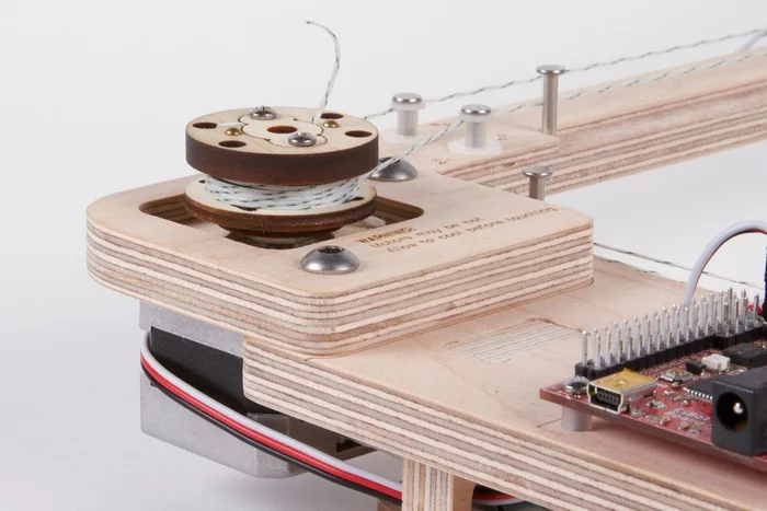 A pair of motors connected to cables handle the positioning of the brush along the X-Y axis, while a carriage with a servo moves it up and down as needed