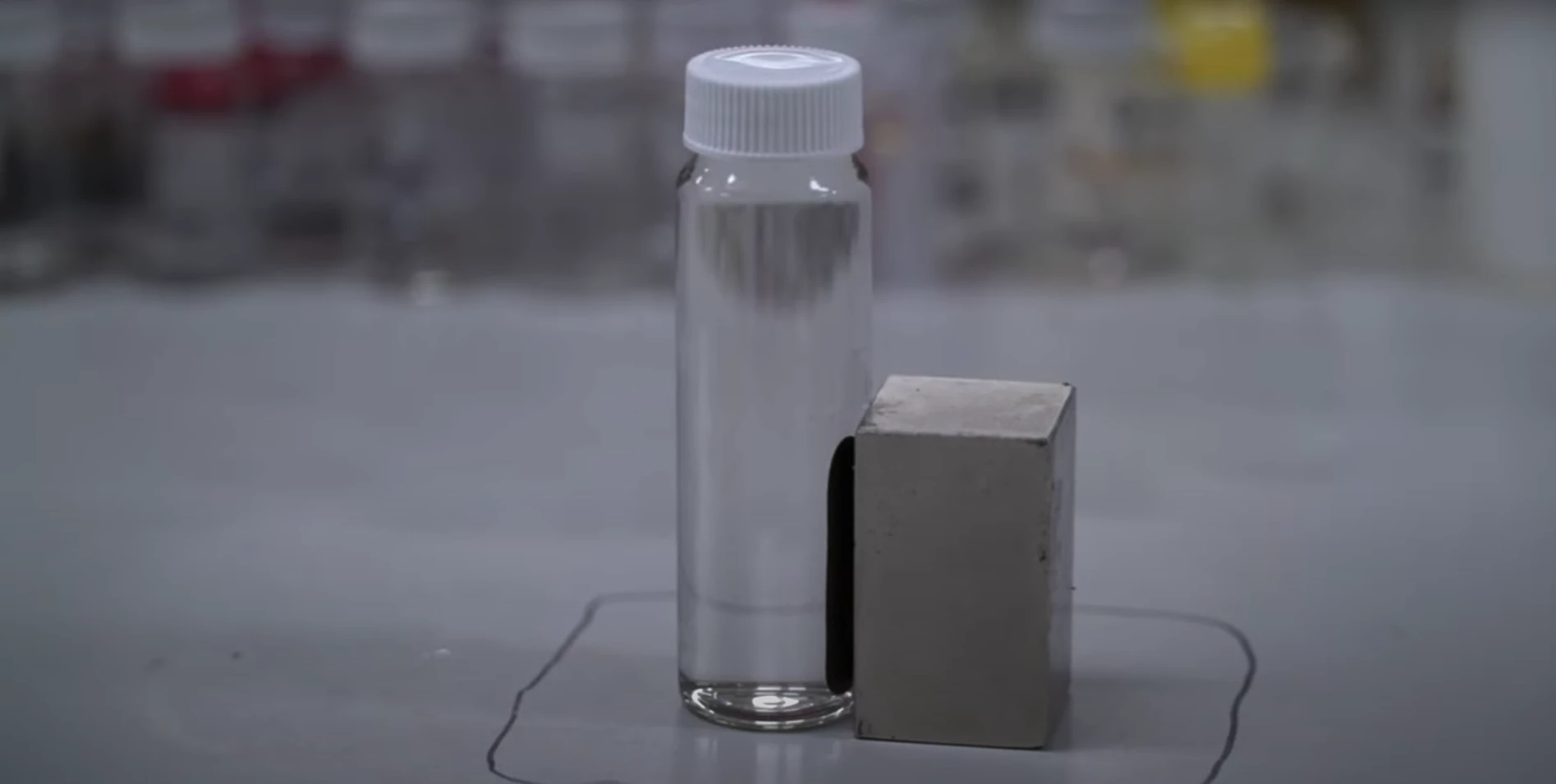A sample of contaminated water being treated using the new technique, with the PFAS chemicals being attracted to the side with the magnet