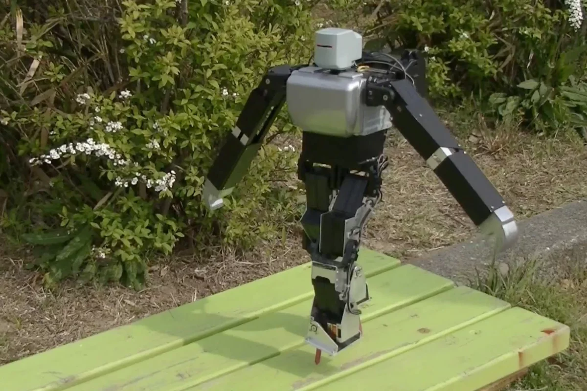 Dr. Guero's hobby robot kit balances on nail-like stilts on a park bench