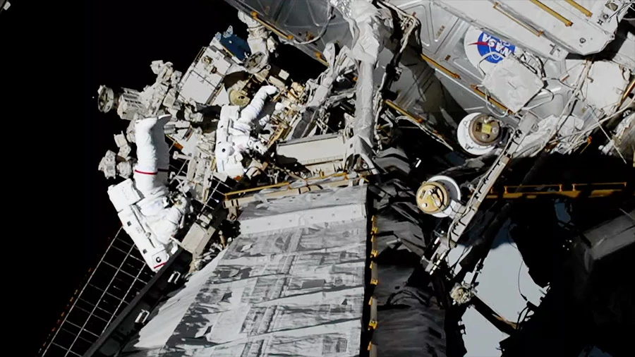 NASA spacewalkers Christina Koch (foreground, suit with red stripe) and Jessica Meir (suit with no stripes) replaced a failed battery charge-discharge unit with a new one during a 7-hour, 17-minute spacewalk