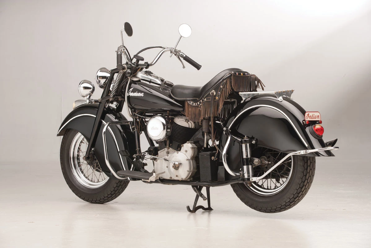 In the book “McQueen’s Machines: The Cars and Bikes of a Hollywood Icon” by Matt Stone, McQueen biographer William Nolan conveys that in the fall of 1951, McQueen had “saved enough money to buy a battered cycle with a sidecar (removed at an unstated time), which he proudly tooled around the (Greenwich) Village. ‘It was my first bike and I loved it,’ admitted Steve. ‘But I was going with a girl who began to hate the cycle – just hated riding in the bumpy sidecar. She told me, “Either the cycle goes or I go!” ‘Well, there was no contest. She went.’” That battered cycle was this 1946 Indian Chief which, now restored, sold for US$146,750 at an Auctions America sale in August, 2013