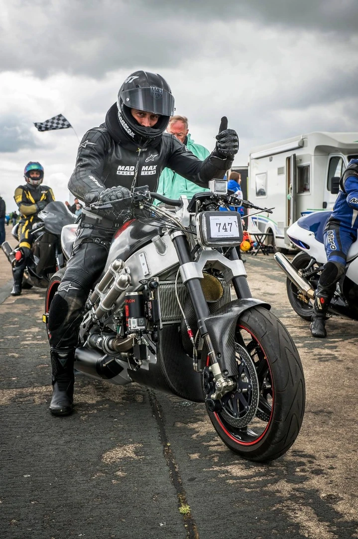 In order to withstand the extreme aerodynamic pressure to his head, Eisenberg attached a metal cable on his helmet's chin and connected it to the bikes frame. The neck brace helps a lot too