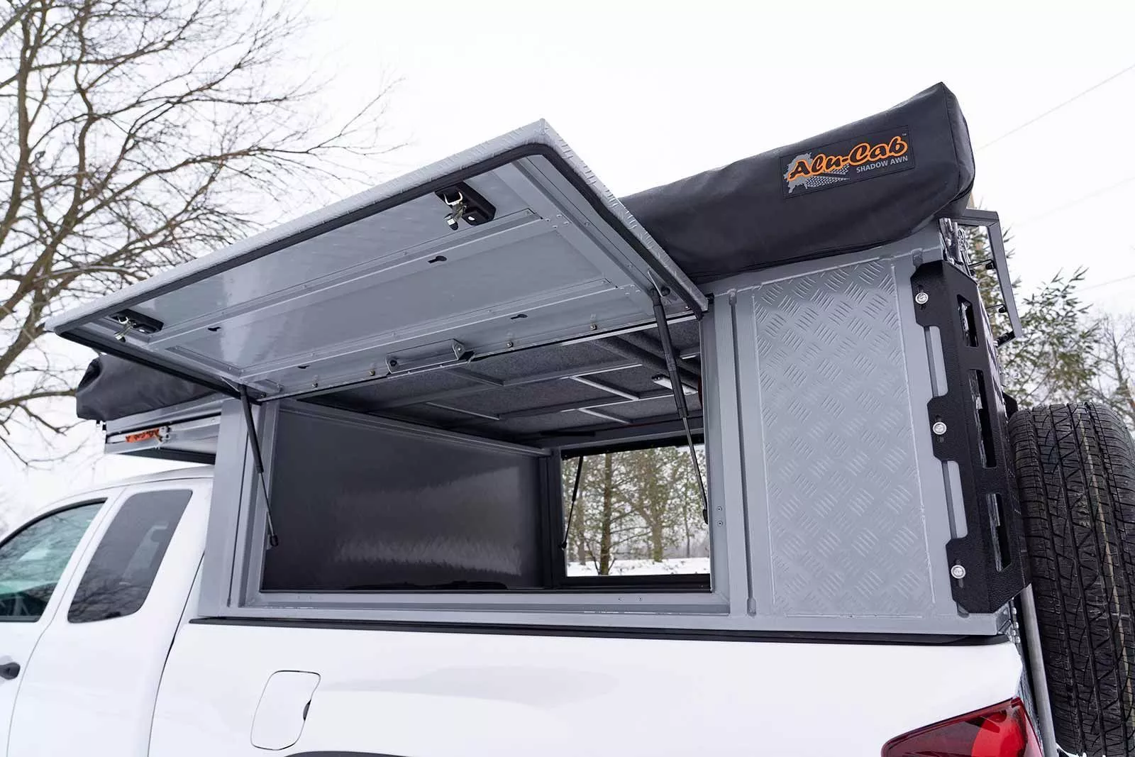 The Alu-Cab Canopy Camper includes dual side hatches for quick bed access
