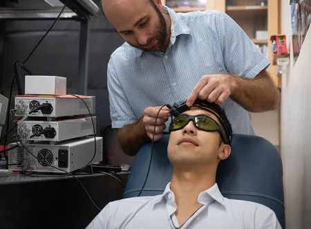 Caltech's Simon Mahler places the CSOS device on graduate student Yu Xi Huang