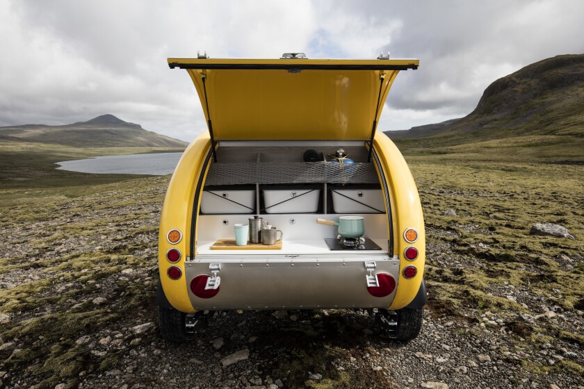 The kitchen is simple and open, featuring a sunk-in ice chest, single-burner stove and organizer bins