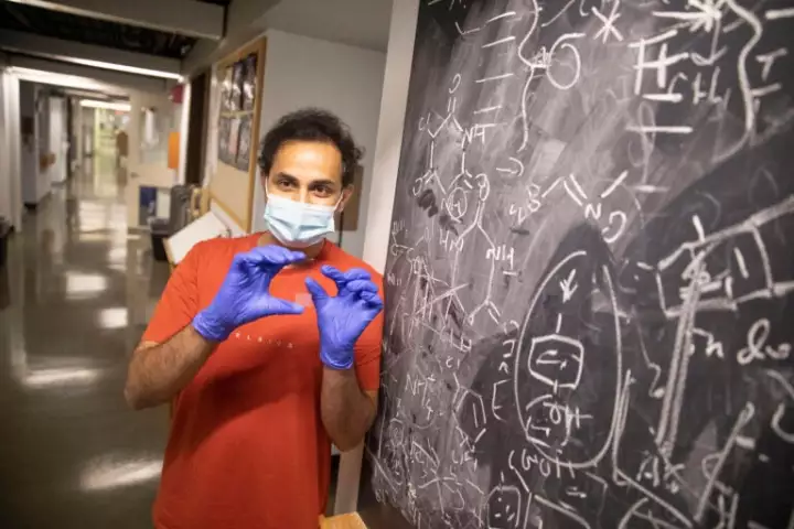 Harvard researcher Amit A. Nagarkar, with an epoxy-coated slide containing the data-storage dots