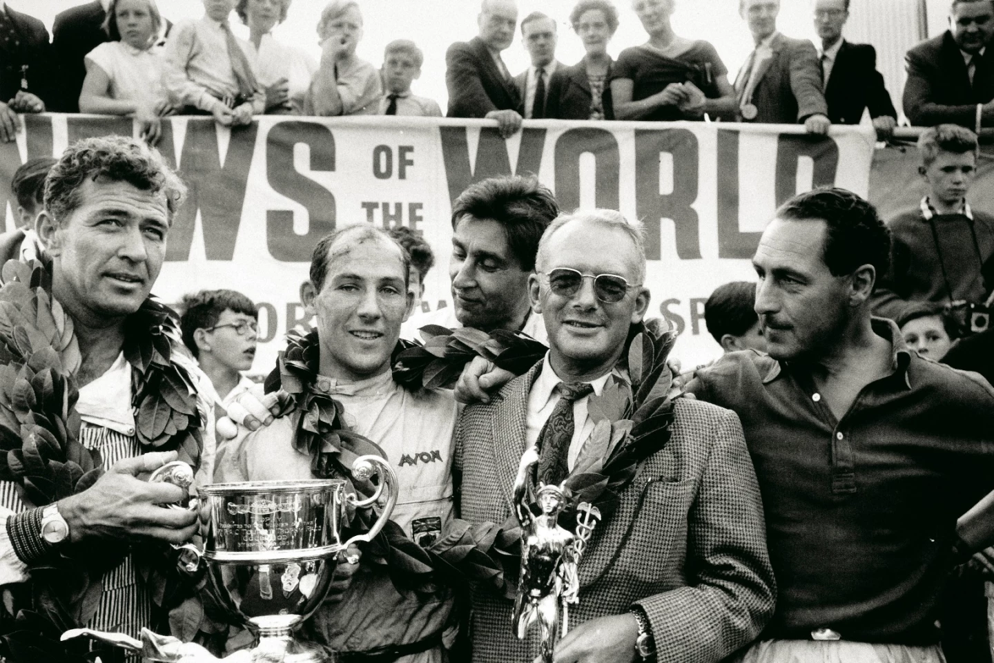 Caroll Shelby, Sterling Moss, David Brown and Roy Salvadori gather on the podium after the 1959 R.A.C. Tourist Trophy on September 5, 1959, the 24th running of the event sponsored by English newspaper, News of the World, and the fifth and final round of the 1959 World Sportscar Championship. In winning the race, Aston Martin emerged from a 3-way contest with Ferrari and Porsche as the 1959 World Champions. It was one of the greatest triumphs for the marque and David Brown.