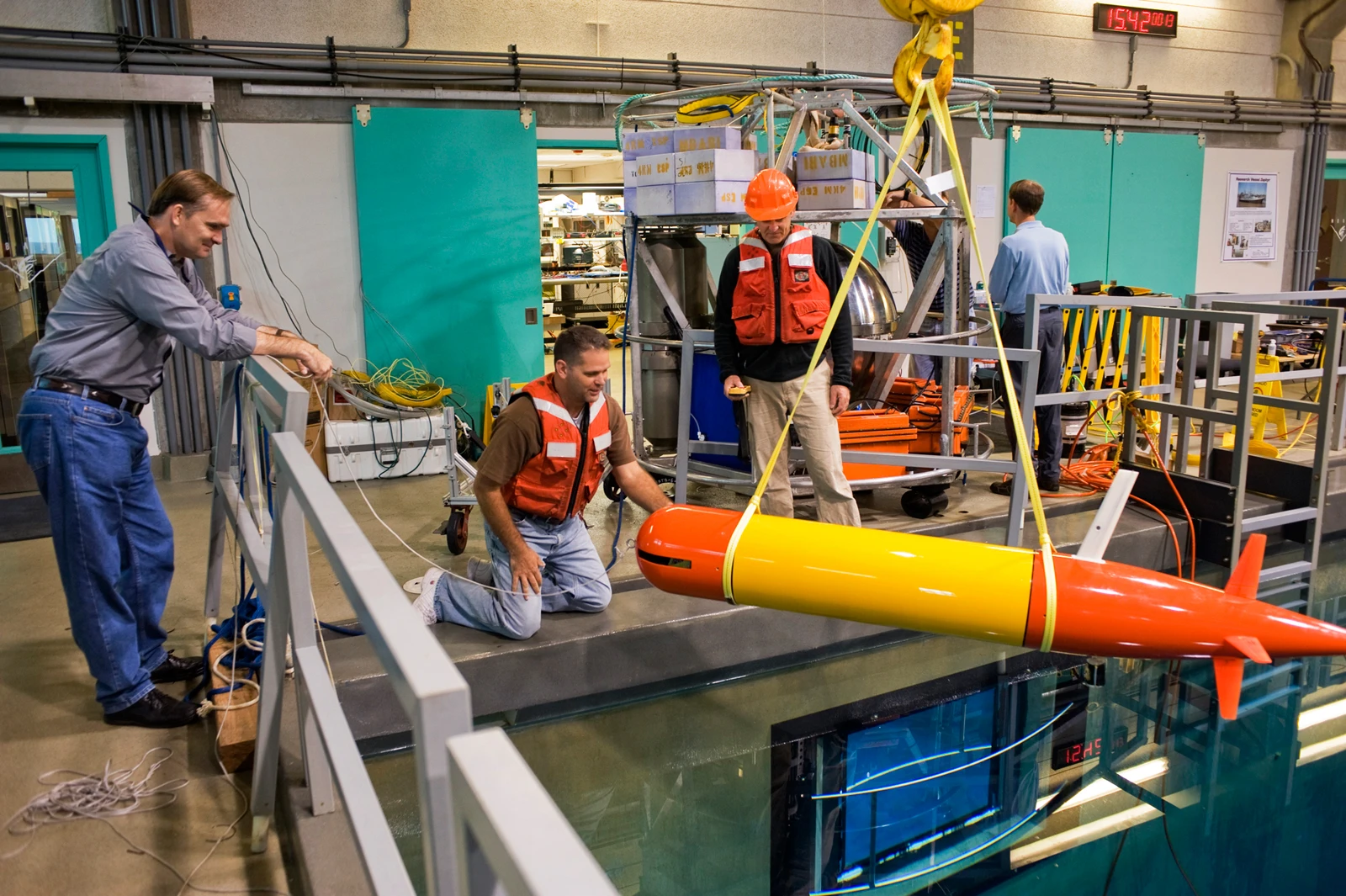 Jim Bellingham, Thomas Hoover, and Bret Hobson work on the long-range AUV in the MBARI test tank (Image: Todd Walsh copyright 2010 MBARI)