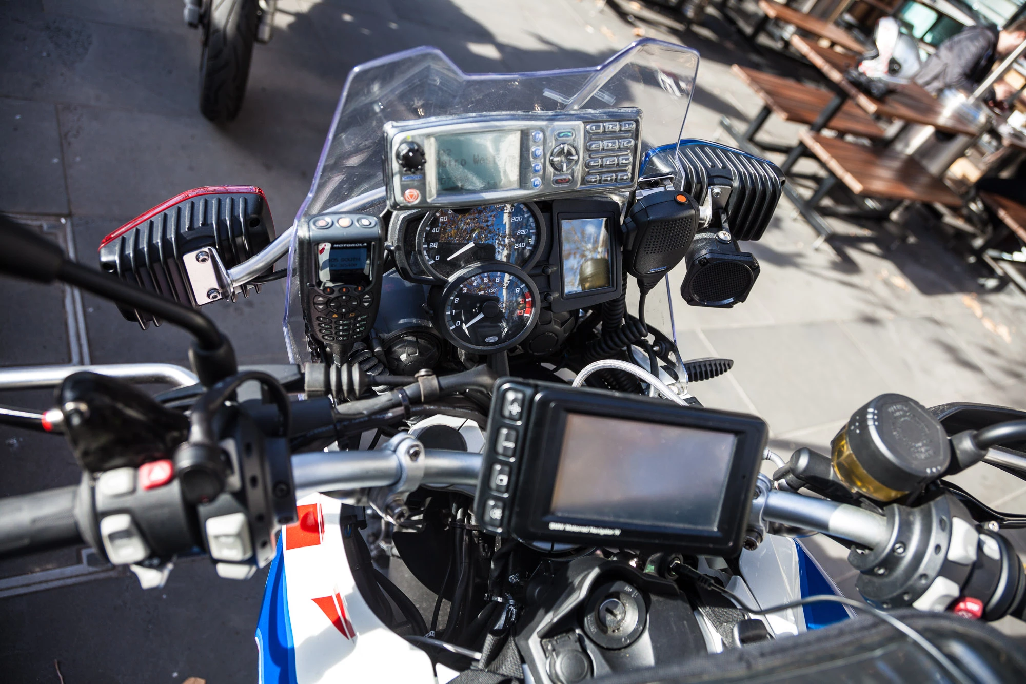 "The dash does look quite... Cluttered. As a motorcyclist we take a few glancing looks at the instrument panel. It doesn't matter that all that stuff's there, most of the time I'm not looking at it. At the top there's a rural radio, on the left is the metro radio. We don't pic up the mic or anything, it all goes through the helmet. There's a factory fitted GPS unit, which also talks to the helmet, that's all through that wire down the bottom. It's all interconnected with audio switchers. On the right is an external speaker, so we can hear the radio out of that bike speaker when we're off the bikes, or put one radio channel through the helmet and another through the ear."