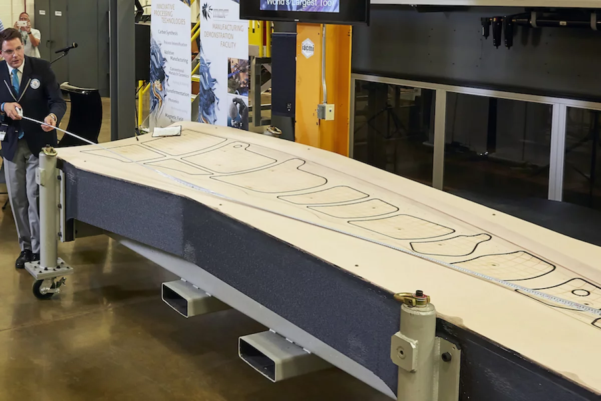 Guinness World Records judge Michael Empric measures ORNL's 3D printed trim-and-drill tool, which is now the world's largest solid 3D printed item