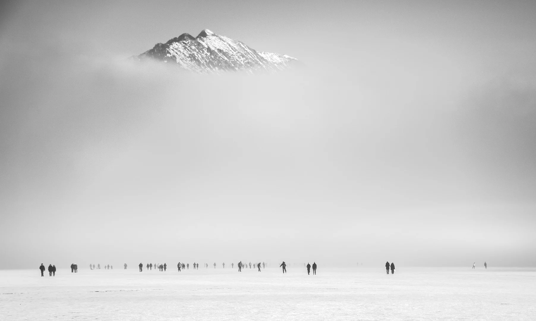 Lake Bled with the surface completely frozen and fog covering the base of the lake