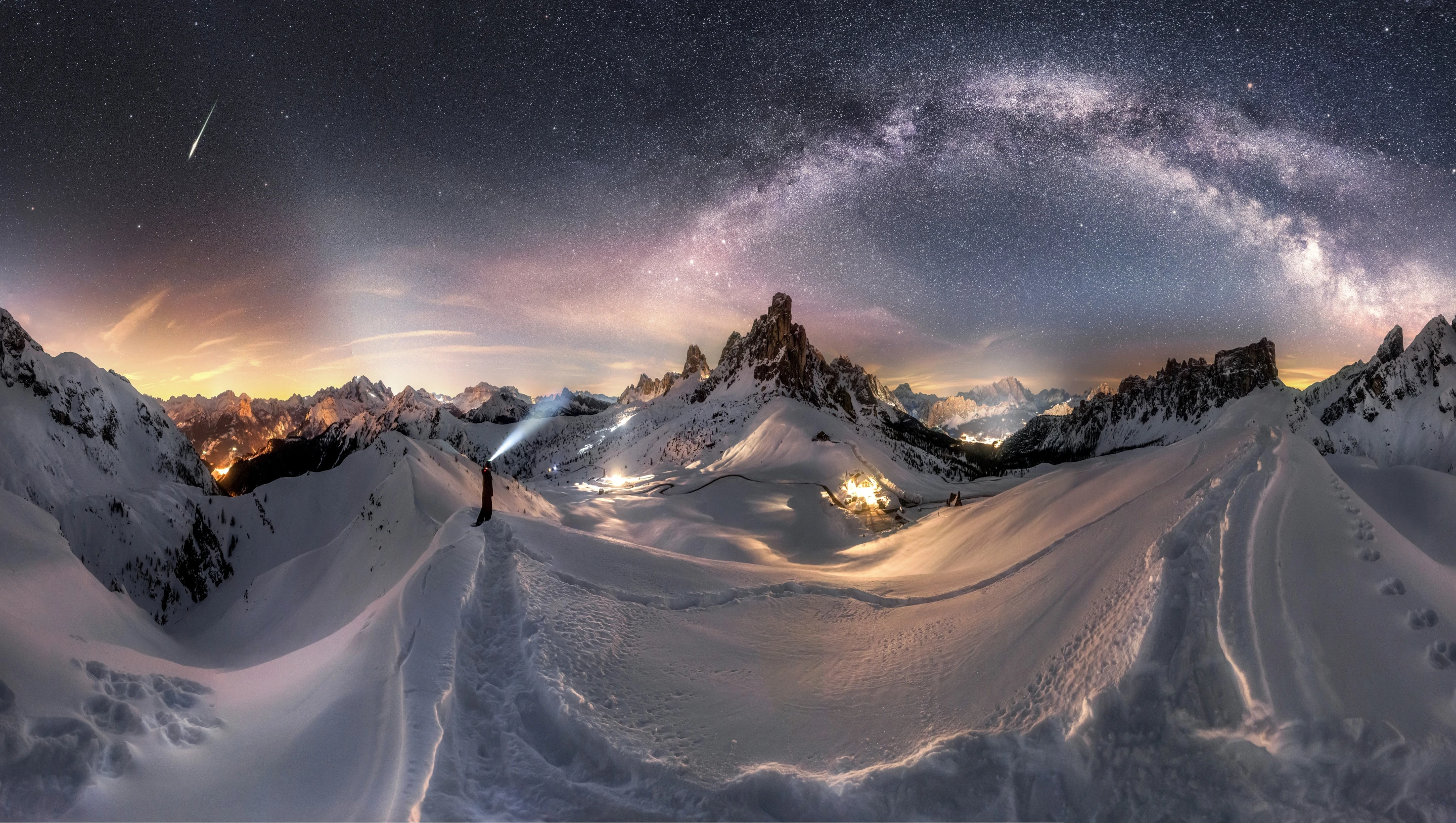 The Milky Way is stretching over the splendid Dolomites dressed in white. The photographer shot the foreground at 7 p.m. in good blue hour and took many vertical images. The Milky Way was captured at 5:30 am the next morning at the exact same position. The photographer composed this panorama using many vertical shots so the foreground and the comet would be perfectly lit. Giau Pass, Dolomites, Italy, 6–7 February 2019