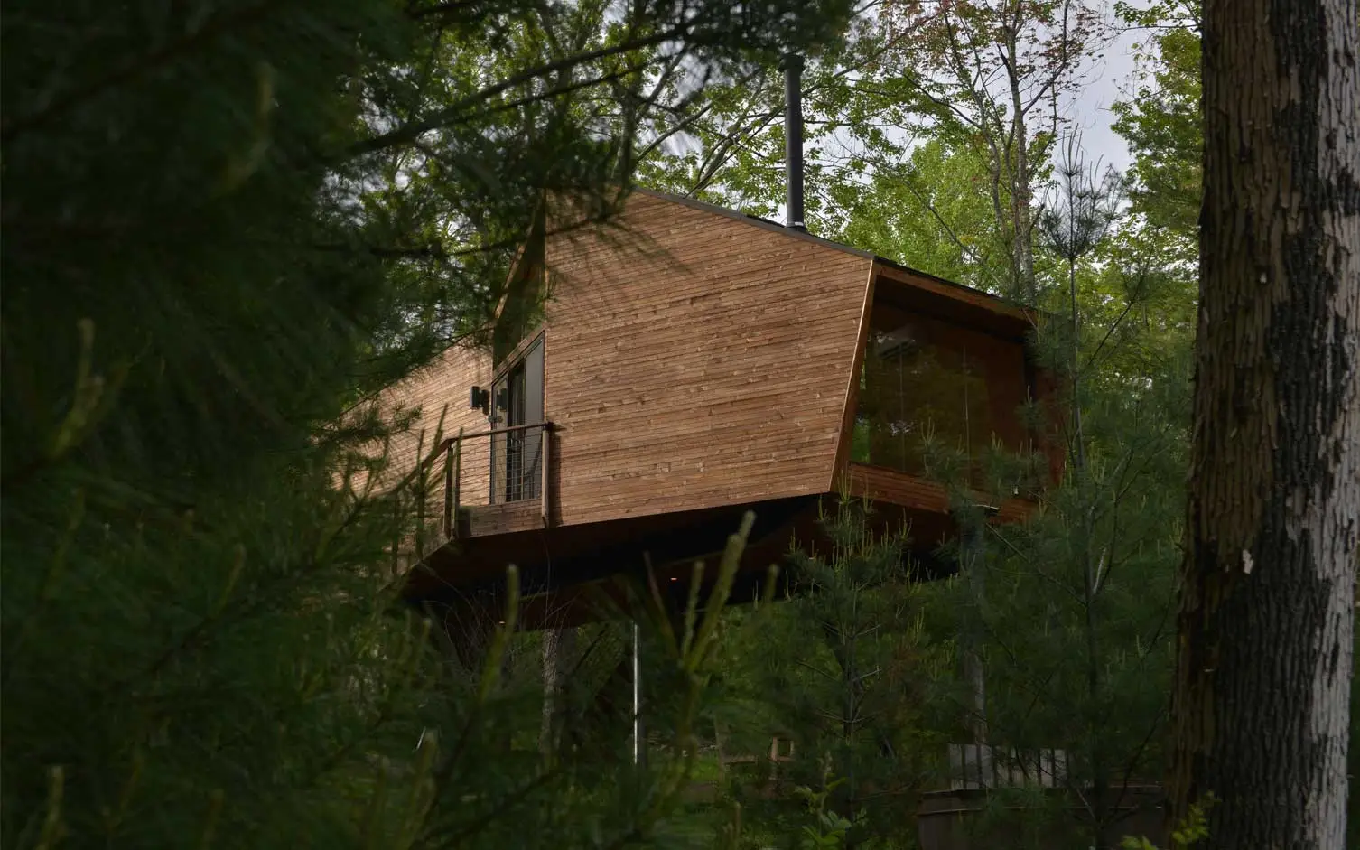 Built using locally sourced materials, the 69 sqm (743 sq ft) Inhabit Treehouse features a geometric structure made from reclaimed FSC timber