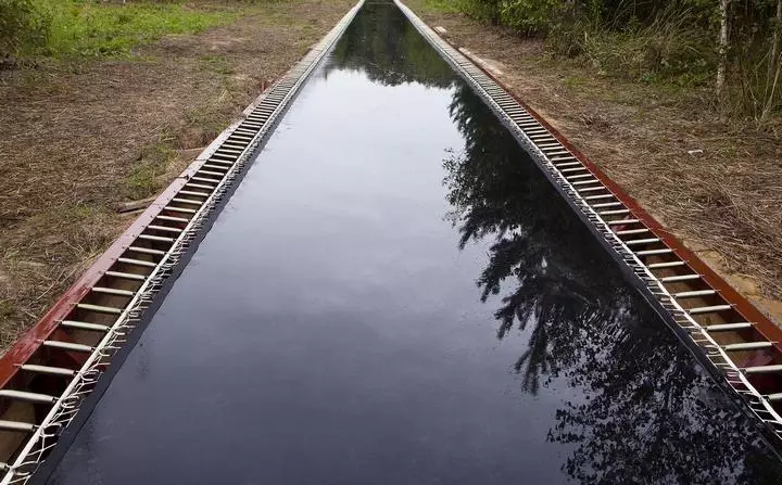 The trampoline road installation is located in the Nikola-Lenivets forest, Russia