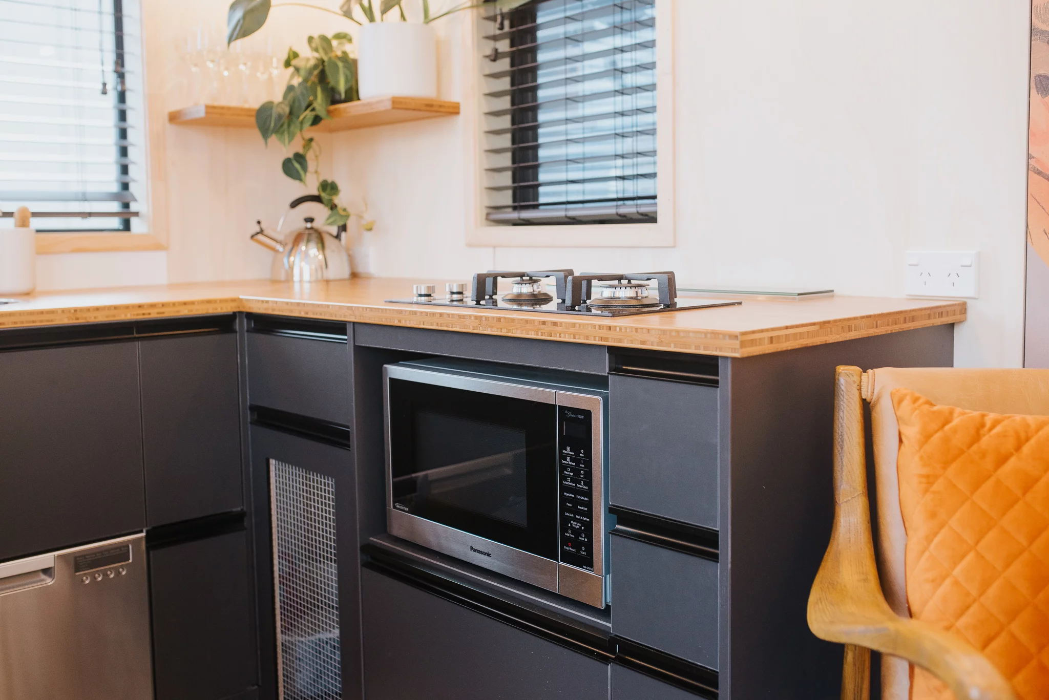 The Autumn's kitchen includes a two-burner propane-powered stove, a dishwasher, and a microwave