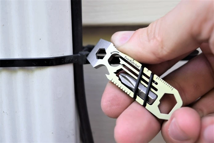The EverRatchet multitool's scraper implement at work snipping a cable tie