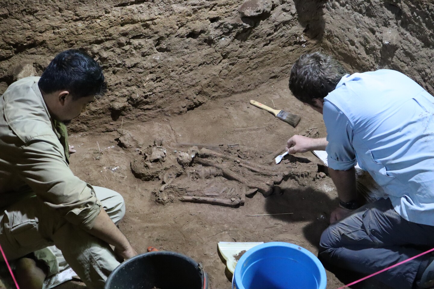 Archeologists Andika Priyatno and Tim Maloney excavate the remains