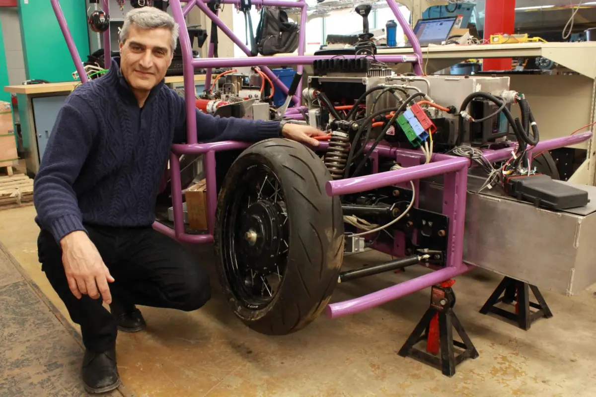 Prof. Amir Khajepour poses with a prototype three-wheeled vehicle that uses the new self-contained wheel units