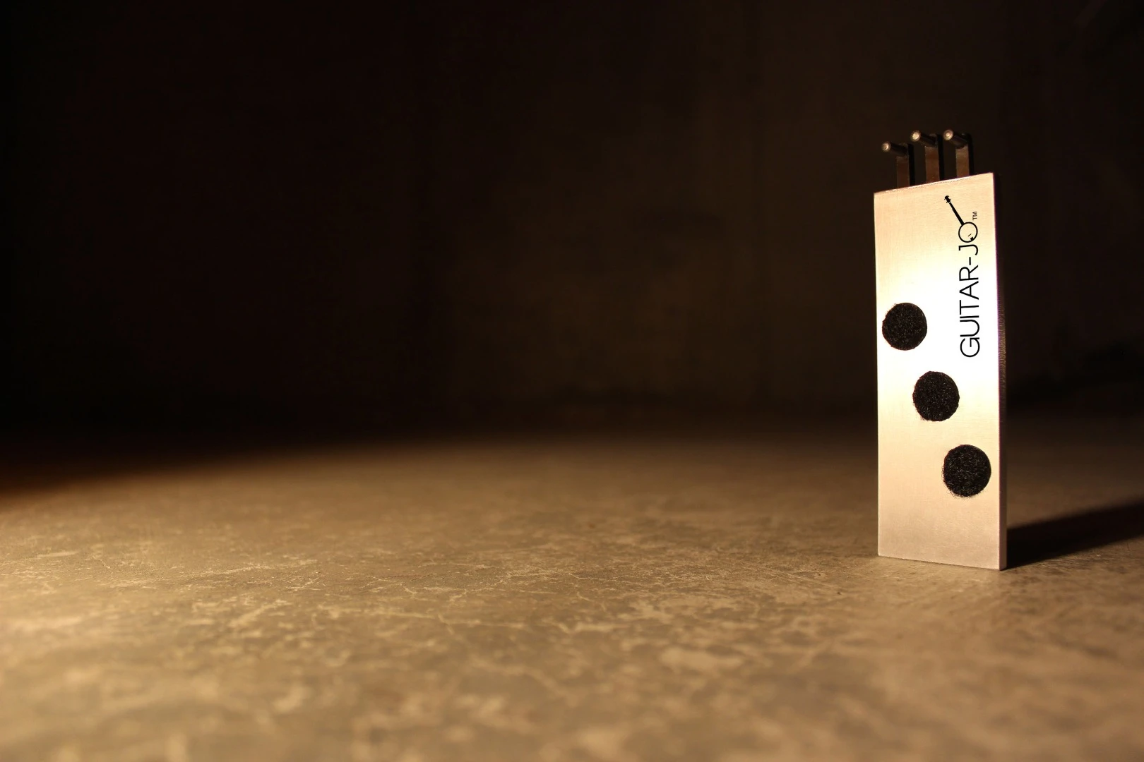 The Guitar-Jo has three circular dampeners located to the front of the slim block body