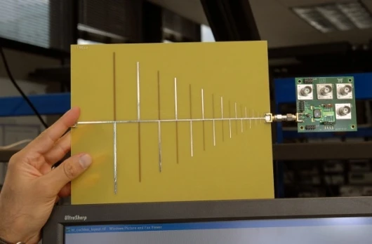 RF cochlea, a low-power, ultra-broadband radio chip attached to an antenna. (Credit: Donna Coveney/MIT)