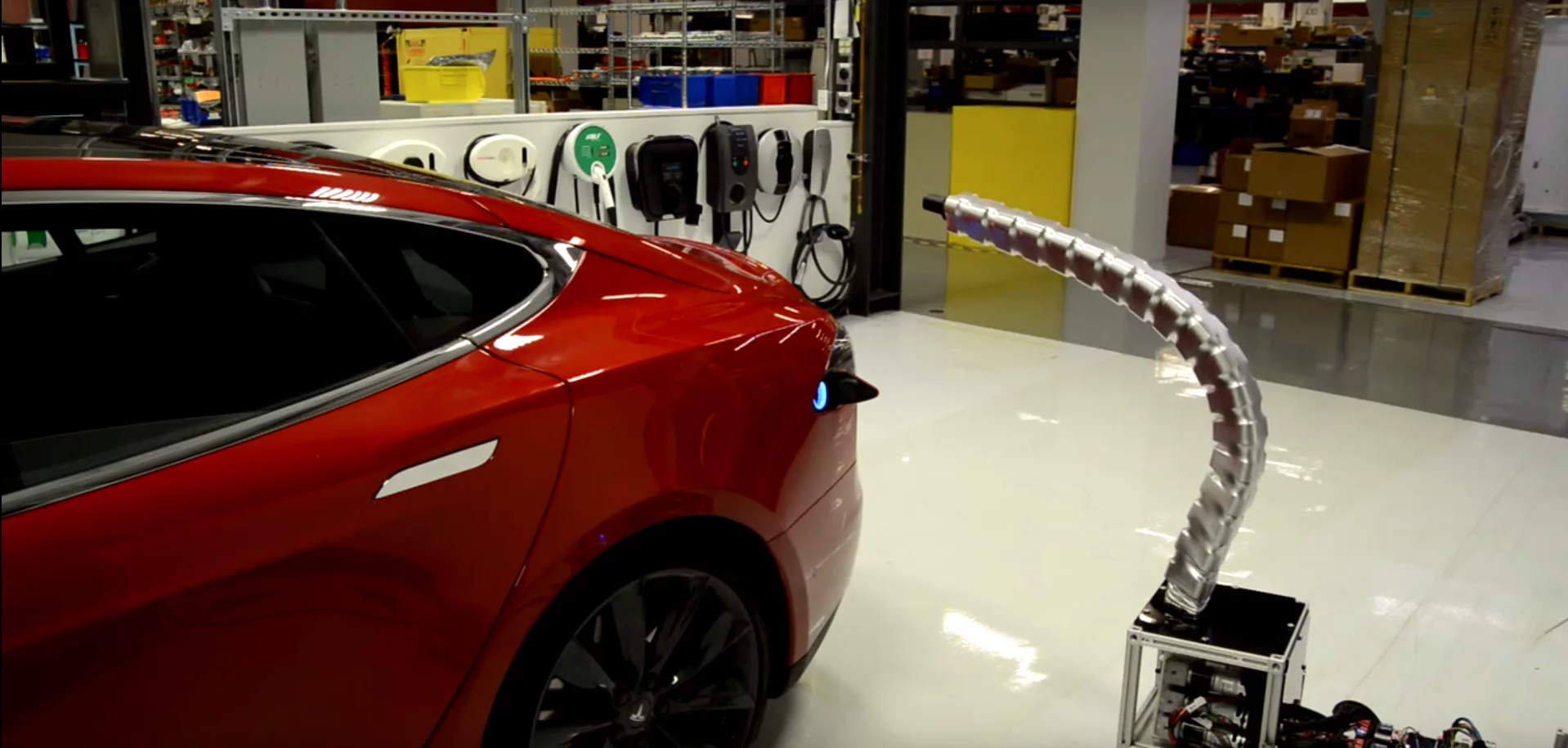 Tesla's prototype robotic charger snaking its way into a Model S