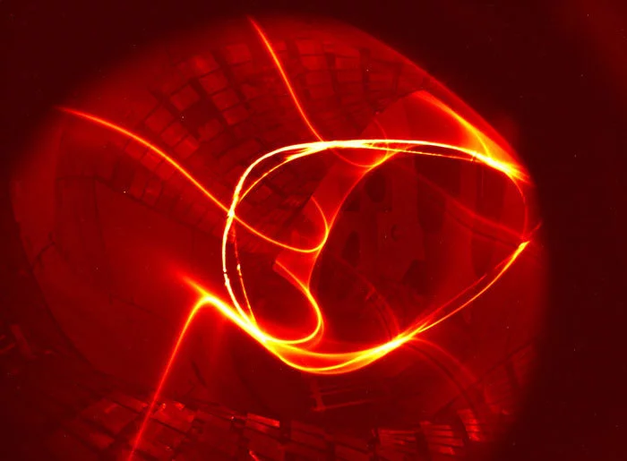 Photograph that combines the tracer of an electron beam on its multiple circulation along the inside of the containment vessel of the Wendelstein 7-X stellarator