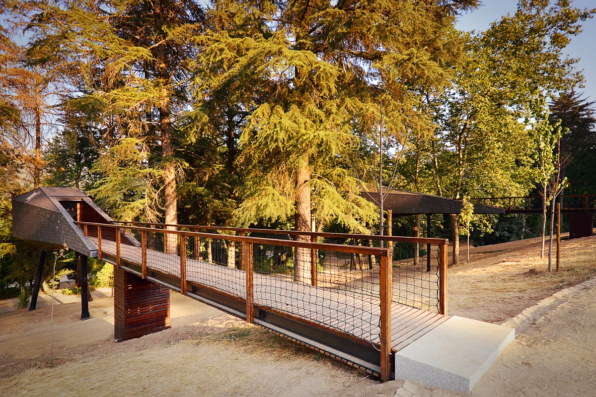 Both dwellings feature a long wooden bridge-like entrance which stretches out from ground level