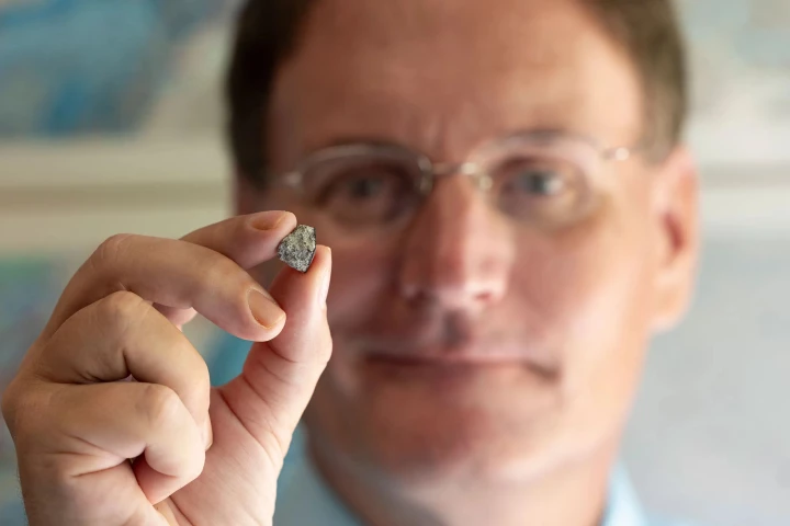 UGA researcher Scott Harris holds a piece of the meteorite that shot down into a man's living room