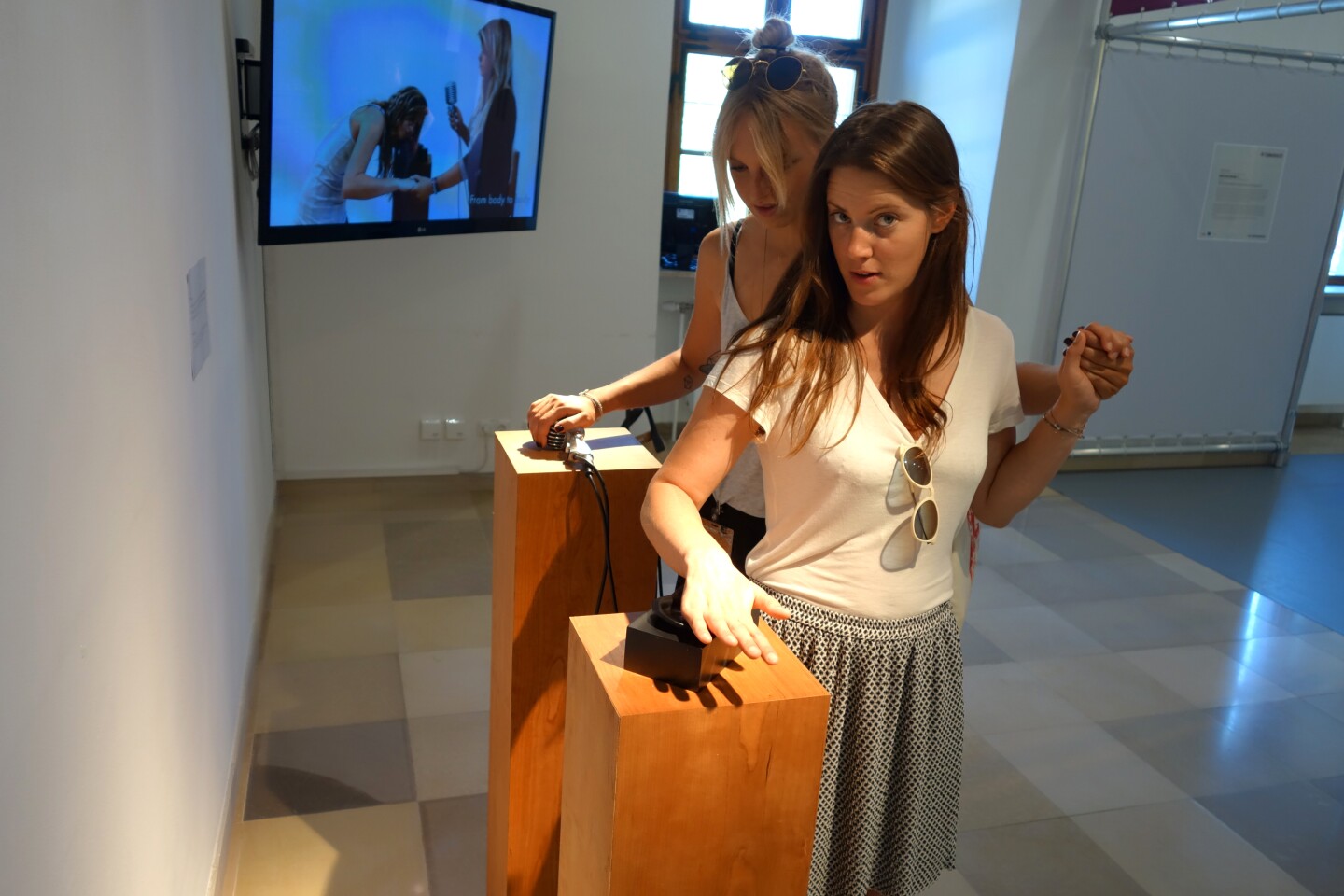 A visitor slides her hand over the ear while holding the microphone to hear the sound (Photo: Disney Research)