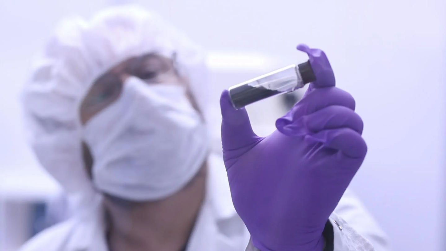 OSIRIS-REx project scientist Jason Dworkin holding a sample of material returned from asteroid Bennu