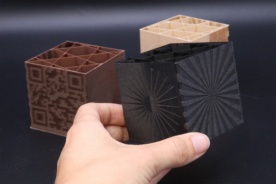 By modulating the speed of the second nozzle, the researchers can vary the shade of materials to create objects with complex patterns