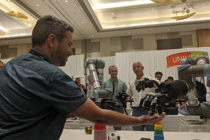 Amazon CEO Jeff Bezos (right) uses the system to manipulate a small soccer ball