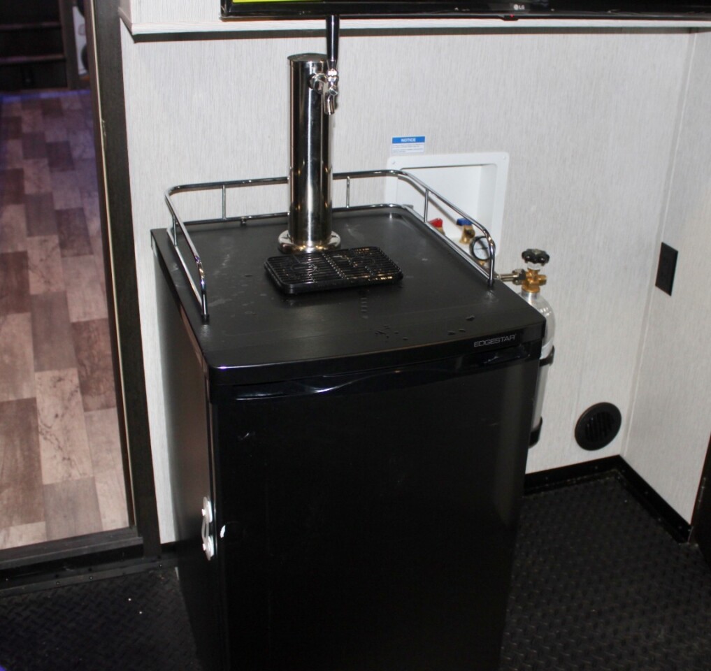 A keg fridge in the garage puts beer on tap