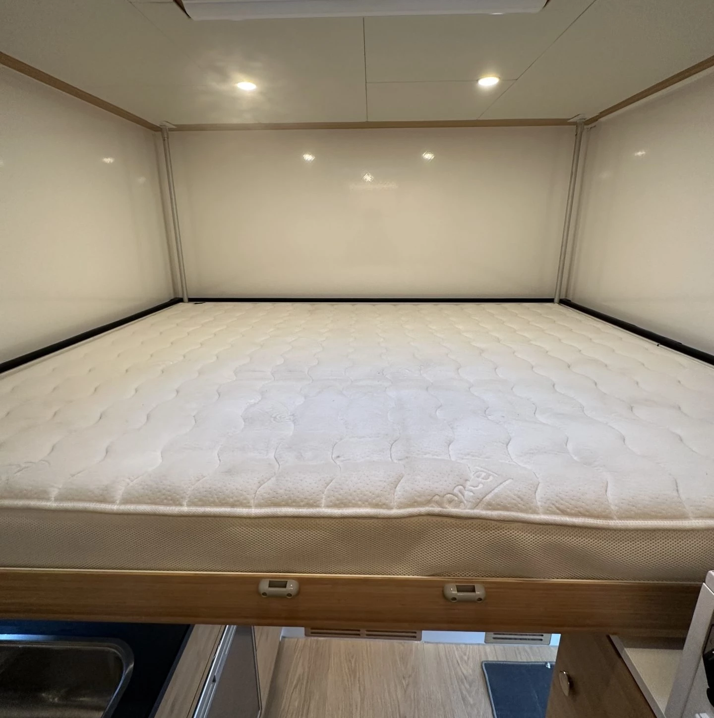 The compact 8-foot module relies on a lowerable queen-size bed that runs the width of the camper module