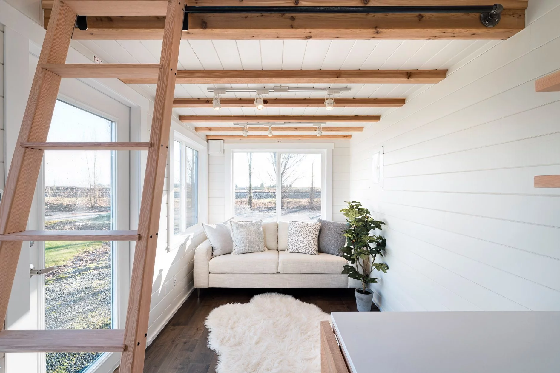 The 34ft Eco-Friendly Tiny House RV's living room is light-filled thanks to abundant glazing