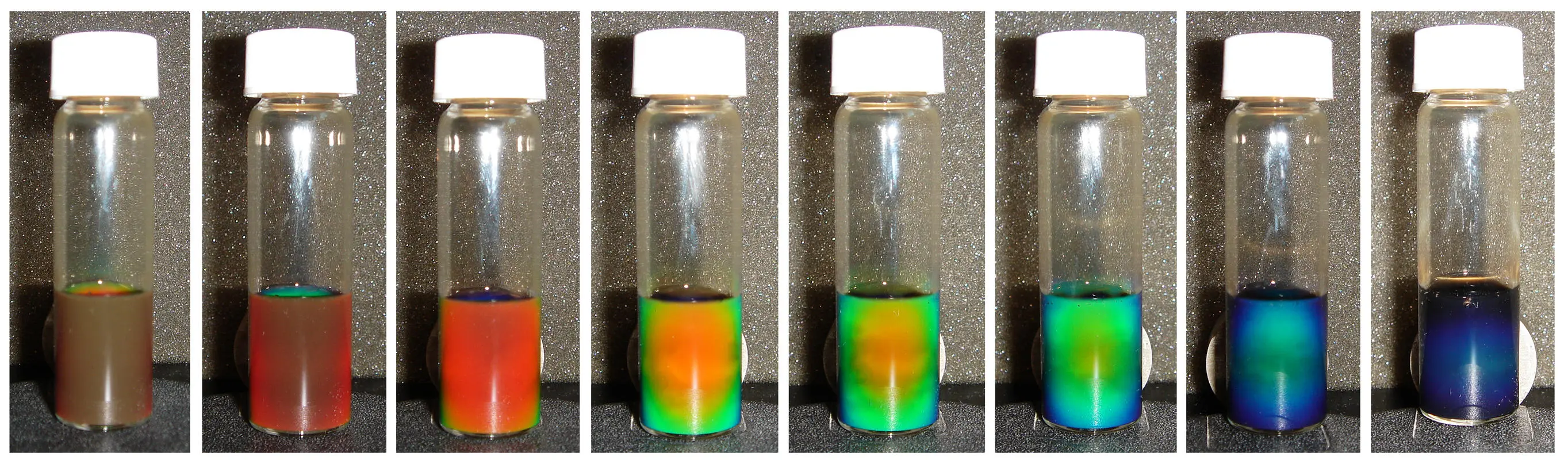 A solution of iron oxide in water changing color under a magnetic field, with increasing strength of the field from left to right (Photo: Yin laboratory, UCR)
