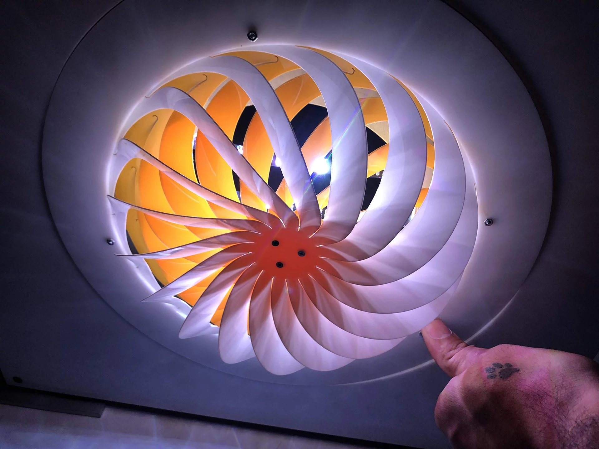 The slats of this Kiriform lamp shade can opened or closed to let out more or less light, by rotating the perimeter of the device