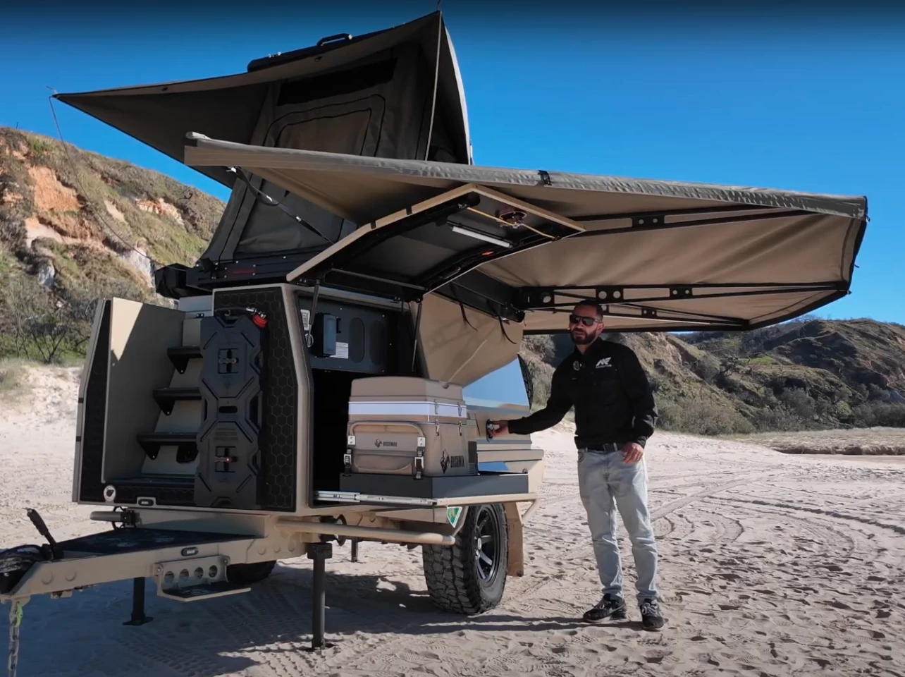 The frontmost storage hatch on the left side of travel has a slide-out fridge drawer down low, the heating system above