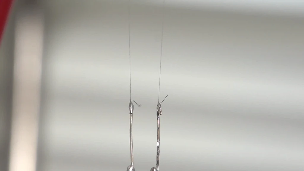 Two strands of the new CNT fiber support and supply current to an LED bulb
