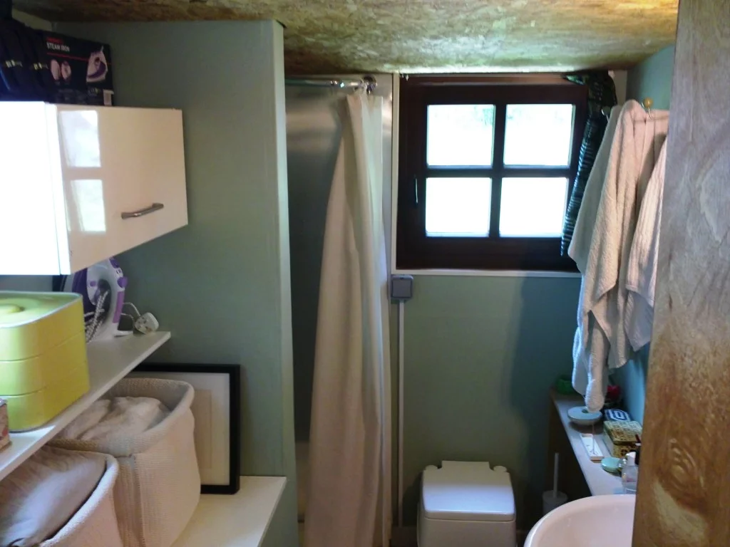 The bathroom with shower and toilet, and room for storage