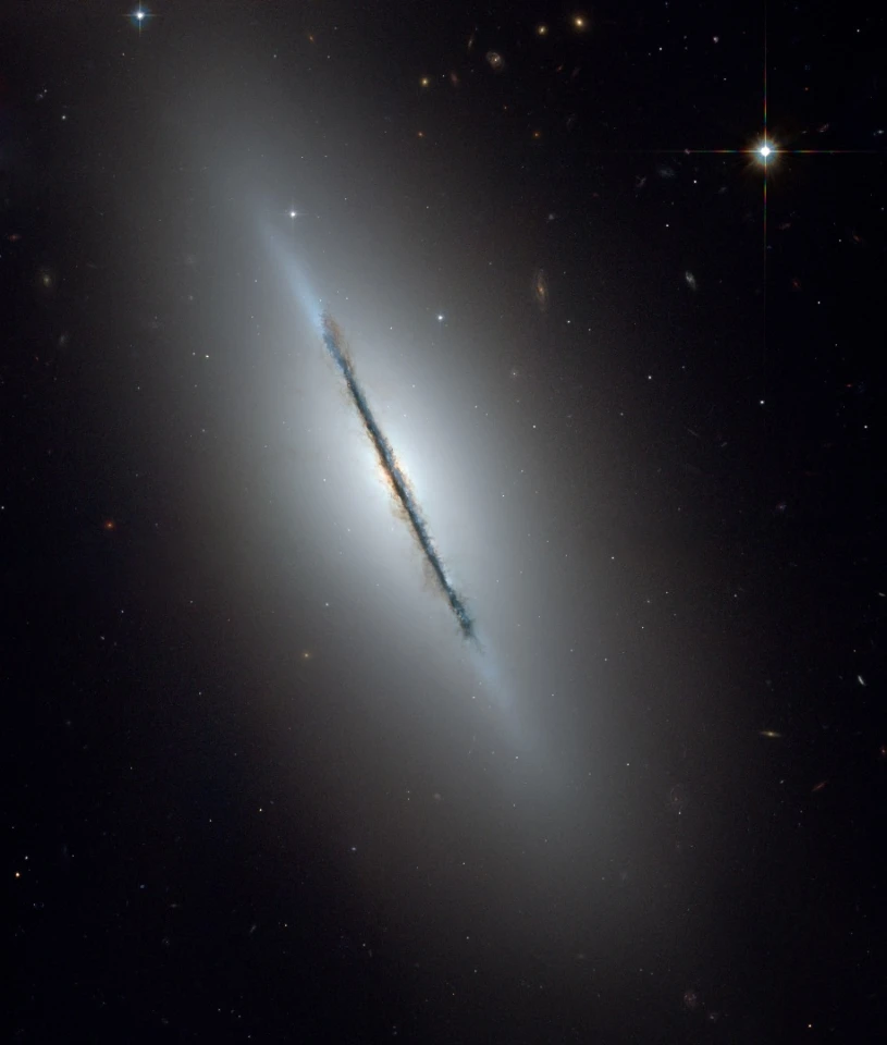 This is a unique NASA/ESA Hubble Space Telescope view of the disk galaxy NGC 5866 tilted nearly edge-on to our line-of-sight