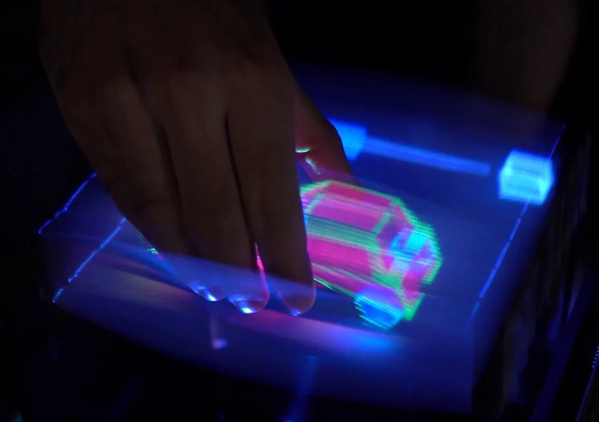A user is able to "grab" the car hologram and manipulate it
