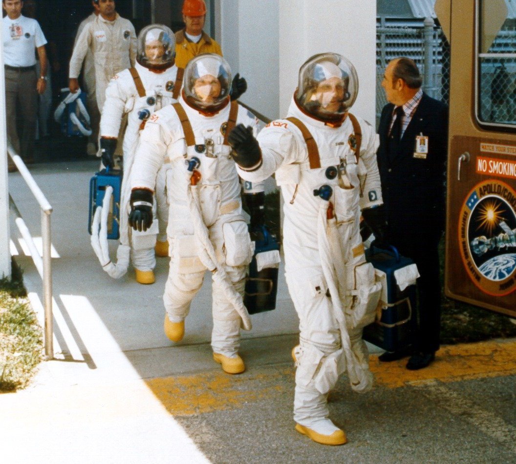 Apollo astronauts carrying portable air conditioning units for their suits