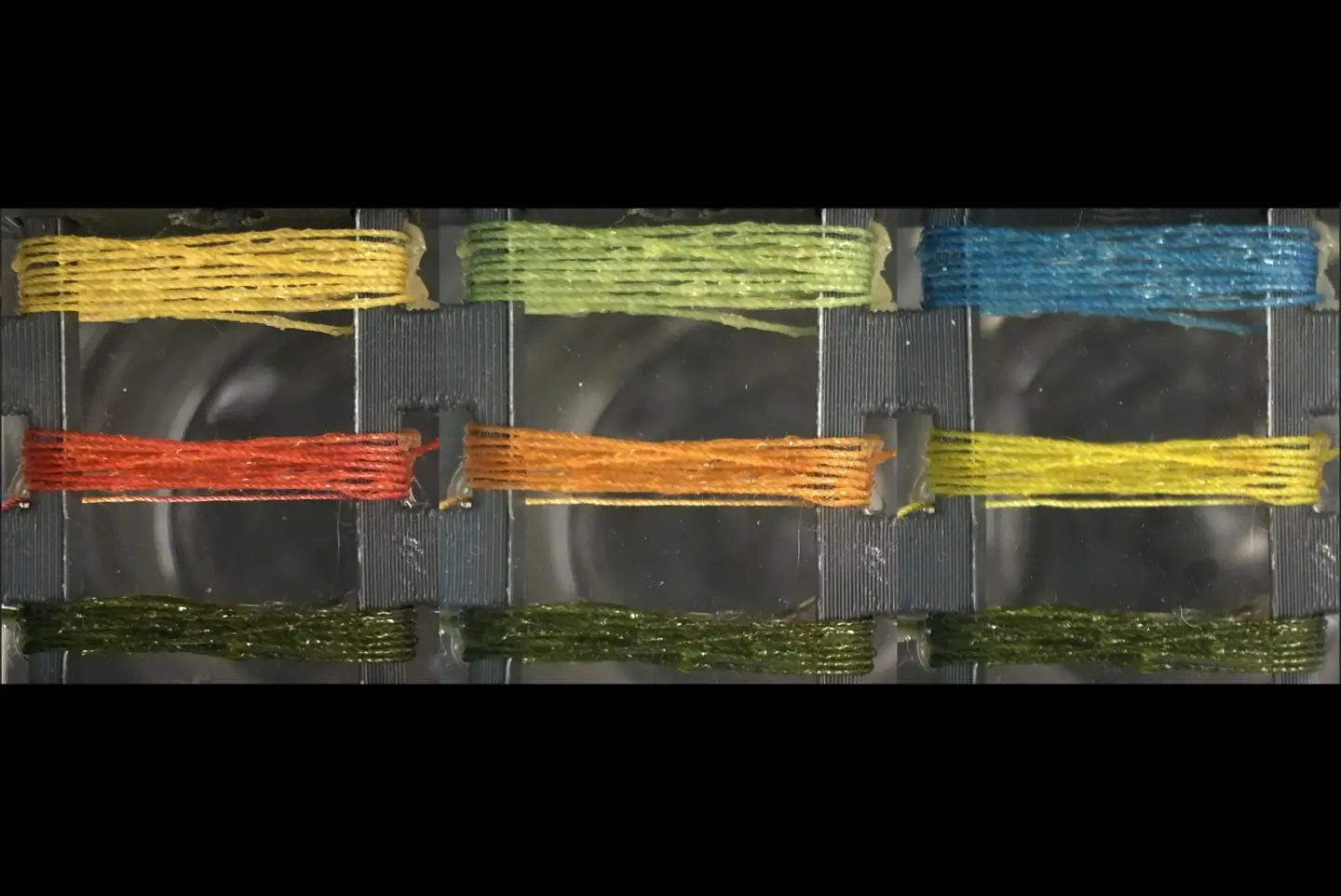 Threads prepared with bromothymol blue (top thread), methyl red (middle thread) and MnTPP (bottom thread) are exposed to ammonia at concentrations of 0 ppm (left panel) 50 ppm (middle panel) and 1,000 ppm (right panel)