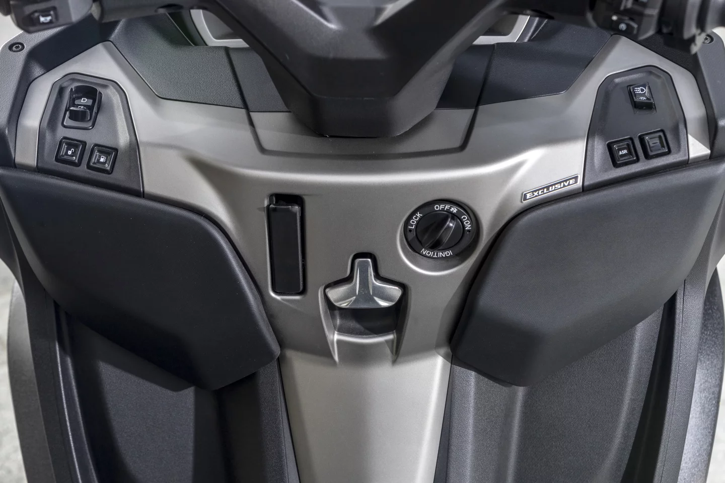 The controls under the handlebars of the 2022 Piaggio MP3 include the central keyless switch, as well as the reverse gear button up left