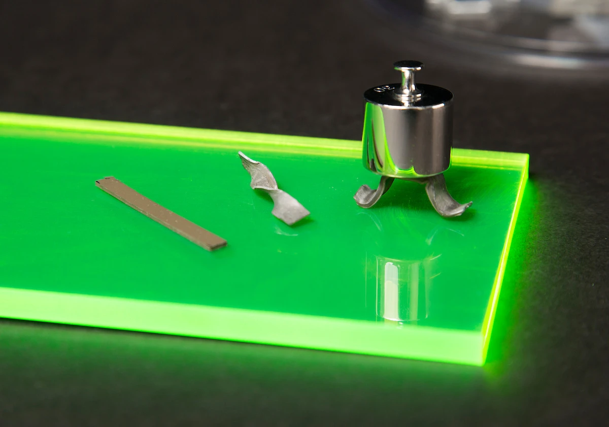 Examples of the new material that turns from rubber to metal under stress: (left) a normal strip of the material, (middle) a twisted strip of the stiffened material holding its new shape, and (right) a demonstration of the strength of the material