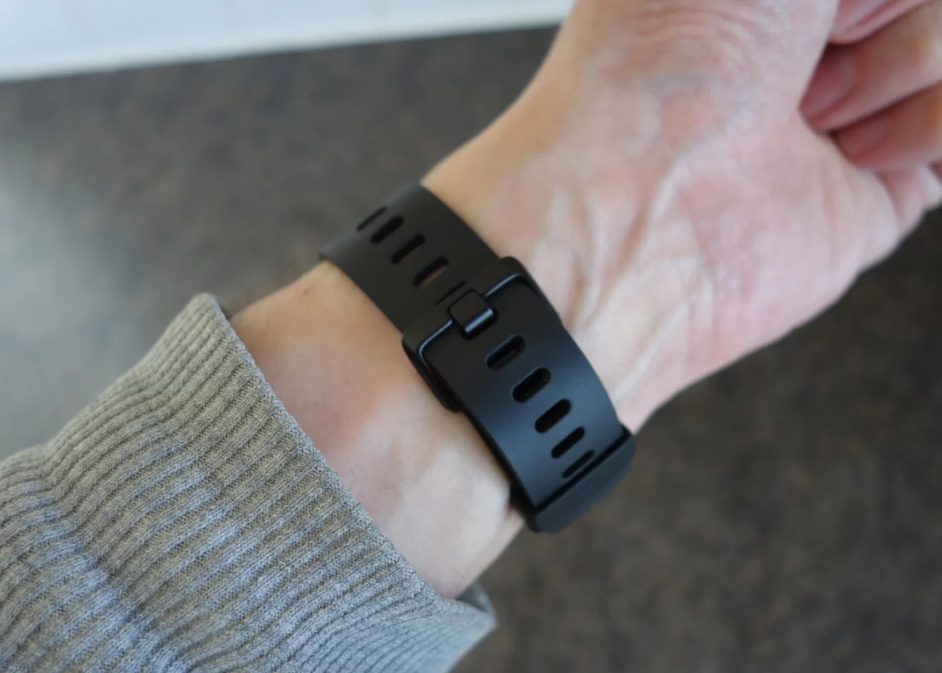 The traditional clasp mechanism on the Fitbit Versa, together with the standard black rubber strap