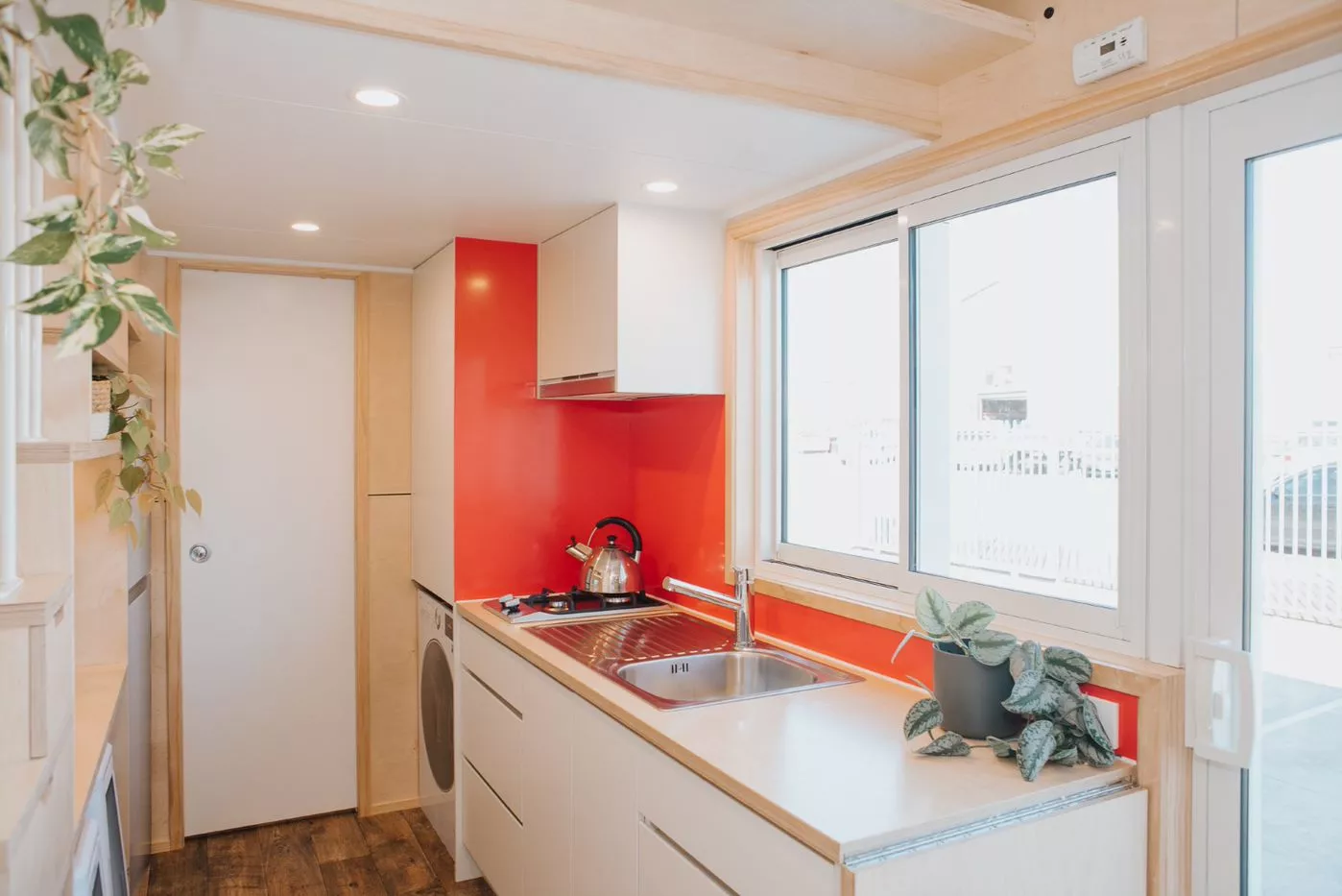 The Babbalucci's kitchen includes a sink, cabinetry, a two-burner propane-powered stove, a fridge, and a washing machine