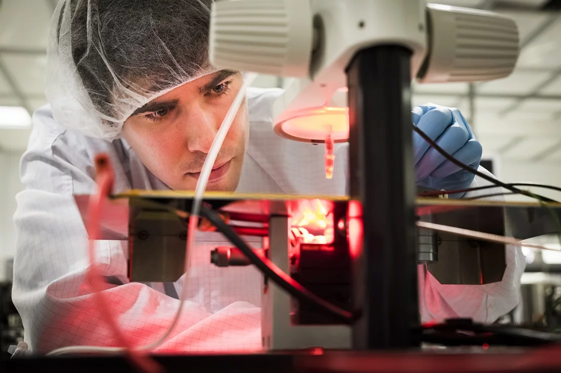 Eric Glowack measures the electrical response of the artificial retina to pulses of red light