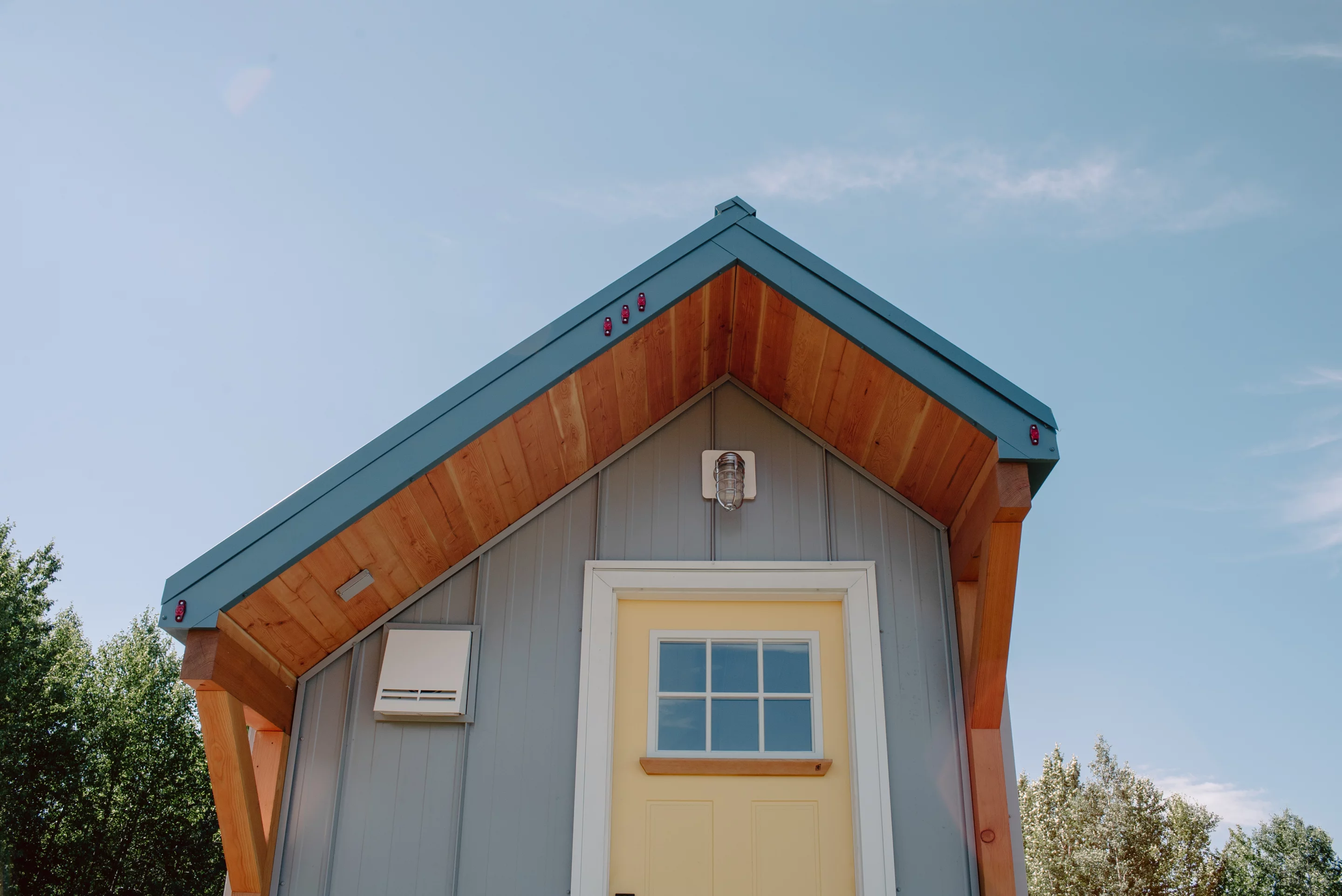 The Macdonald tiny house's main entrance features a small covered porch area